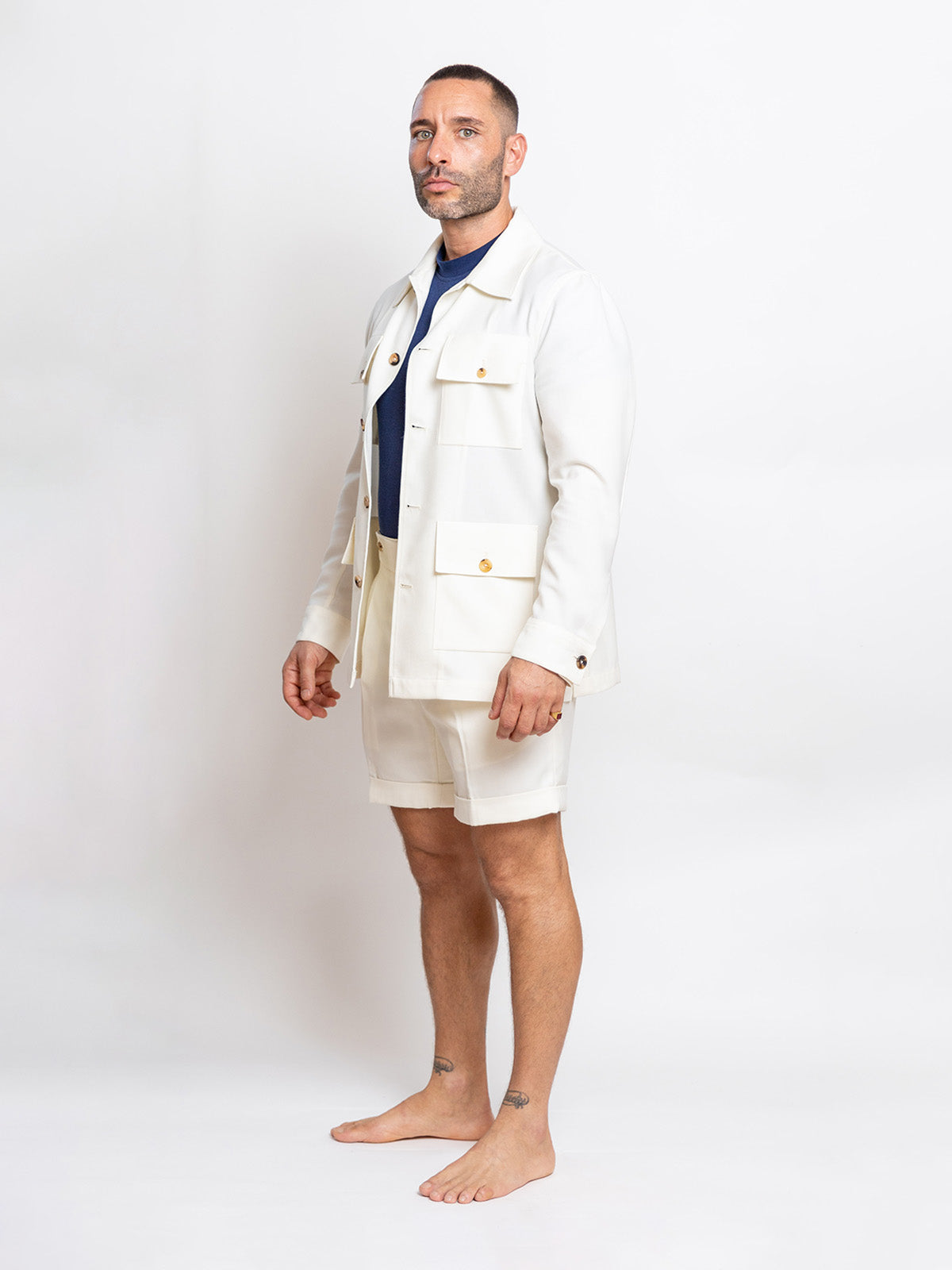 Man wearing a white jacket and shorts on a plain background
