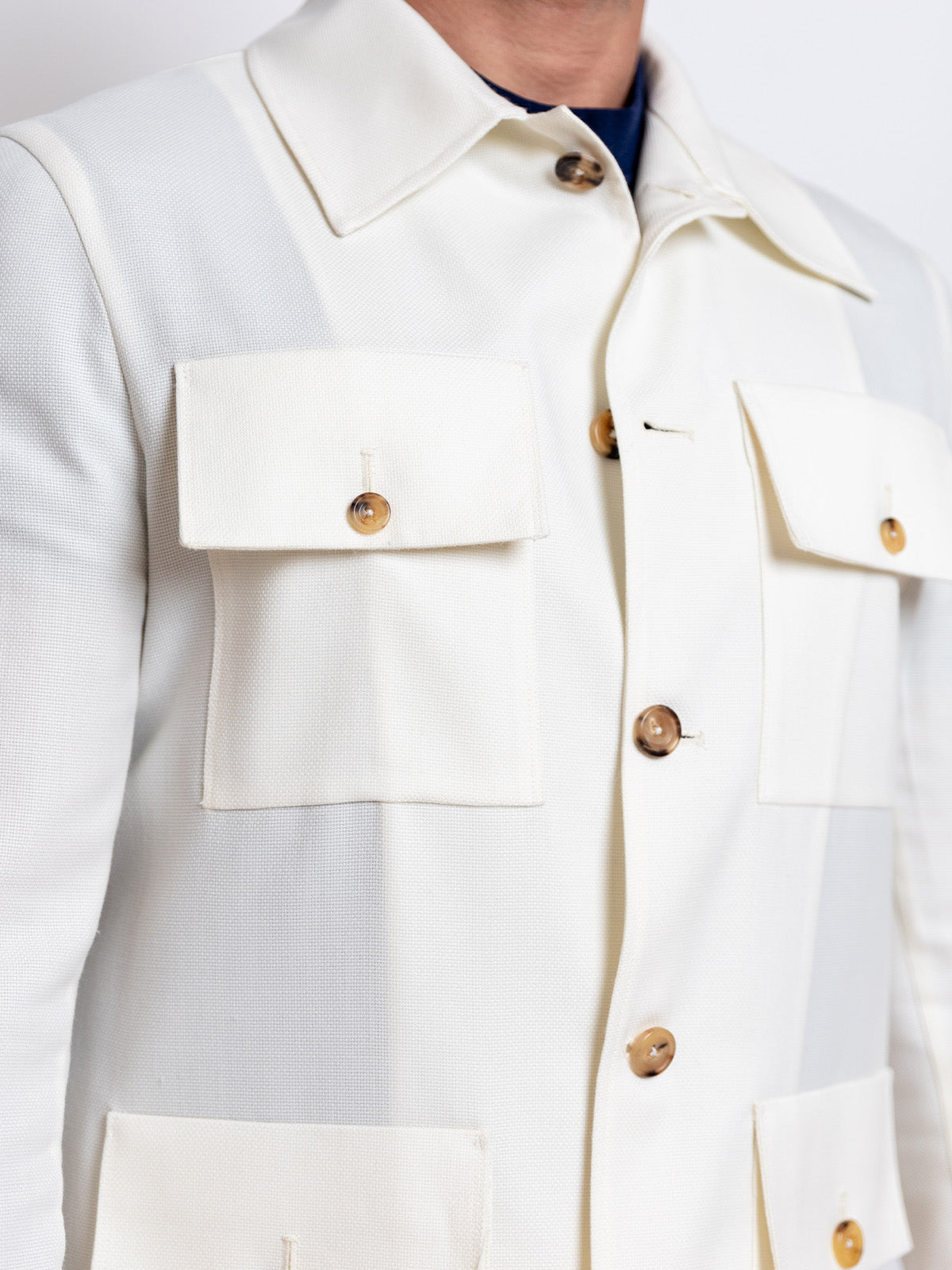 Close-up of a white jacket with buttons on a plain background