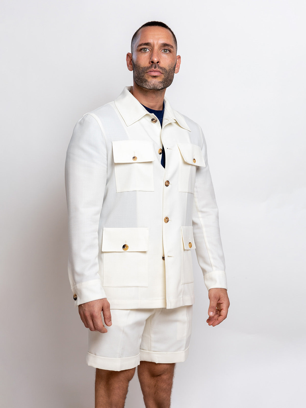 Man wearing a white jacket and shorts on a plain background
